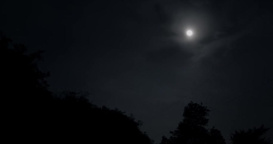 A full moon burns in the sky as clouds pass by