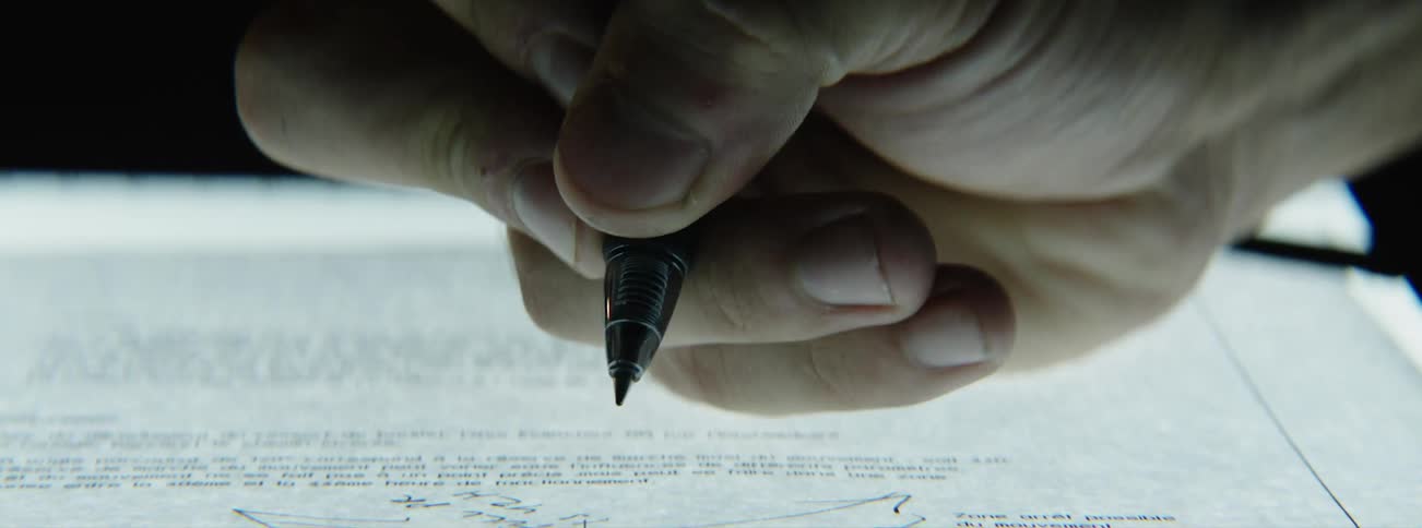 Close up of hand writing notes on sheet of paper
