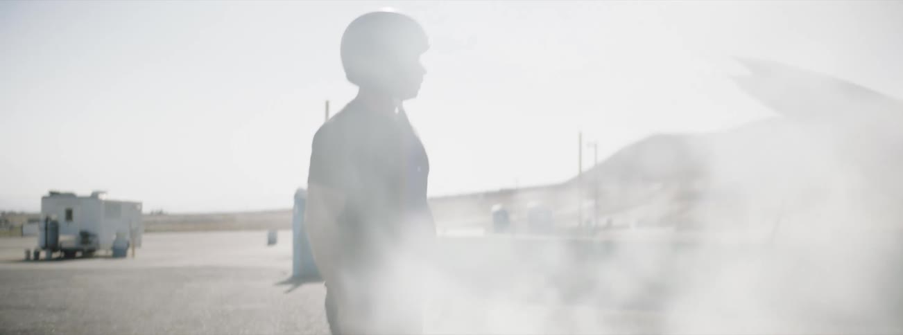 A man is angry and takes off his helmet as a vehicle pours smoke from the hood