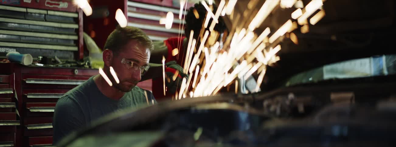 Two people work on a vehicle