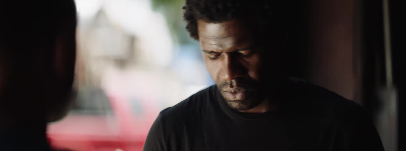 Man glances out window then looks up to meet other mans gaze