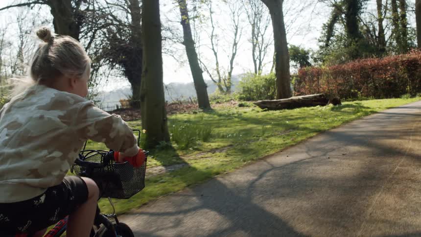 Little child rides a bicycle along the cycle track