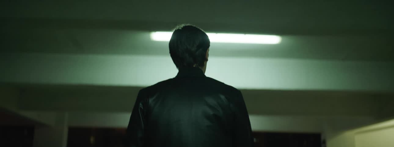 A man walks through a parking garage at night