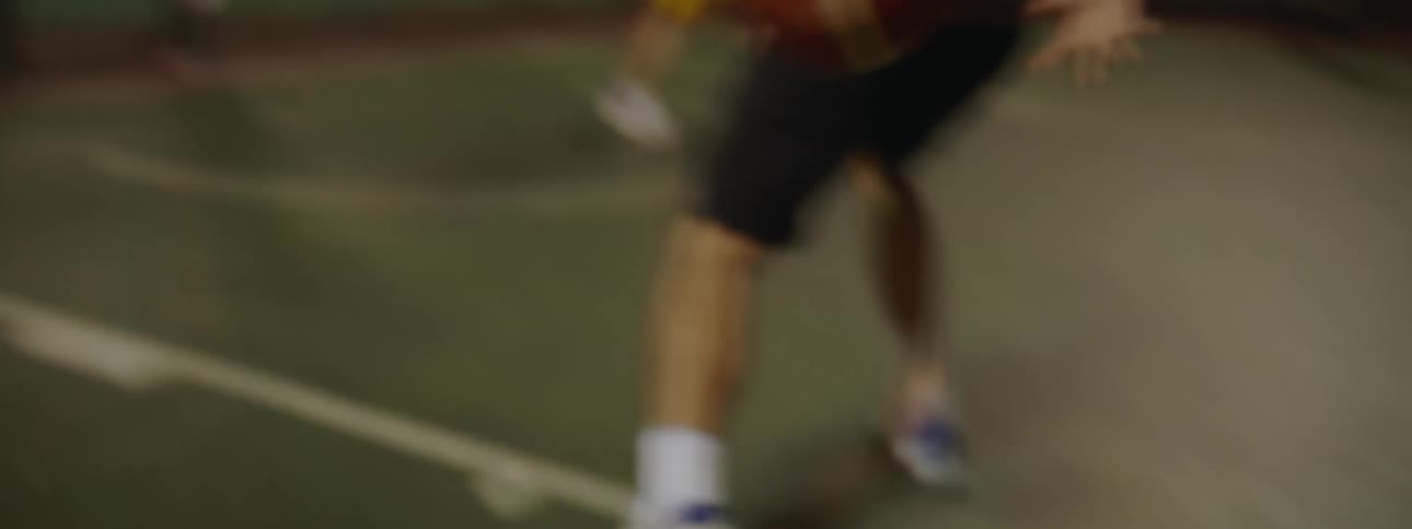 People play basketball on the court at night