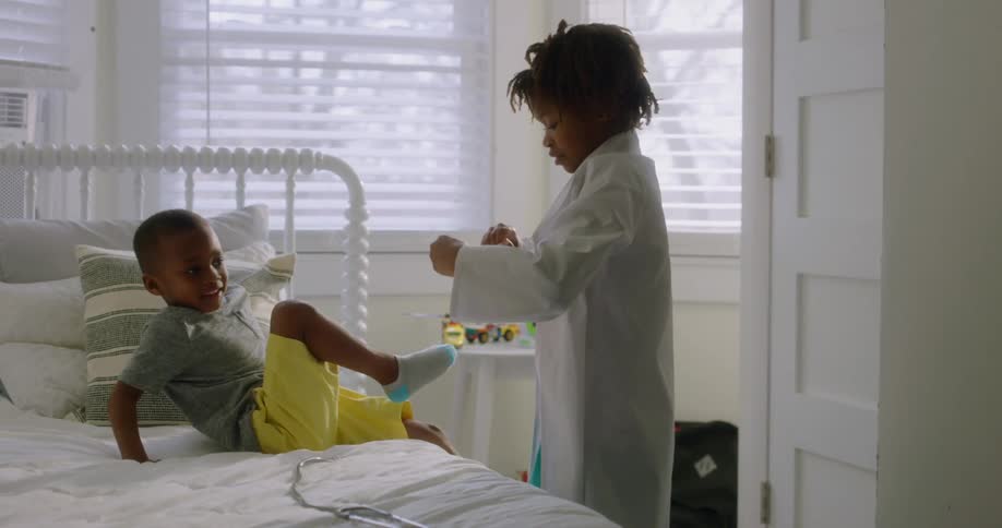 Brother and sister playing make believe in bedroom