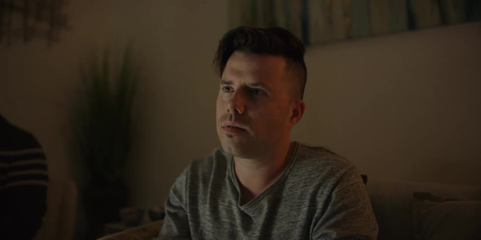 A man sits on a sofa listening and nodding his head in agreement
