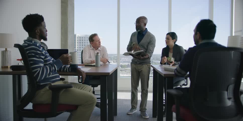 Group of coworkers having meeting in office with large window