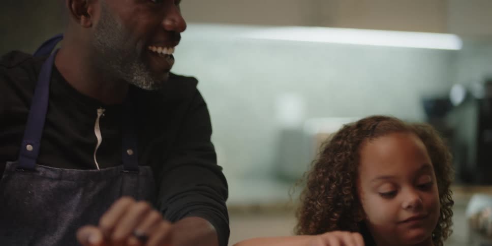 A family talk together in the kitchen by a book