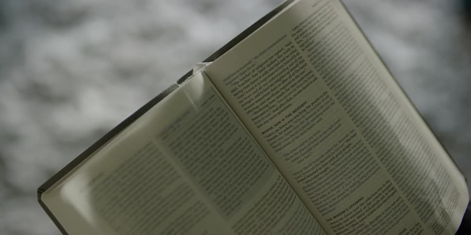 Hand turning pages of a textbook