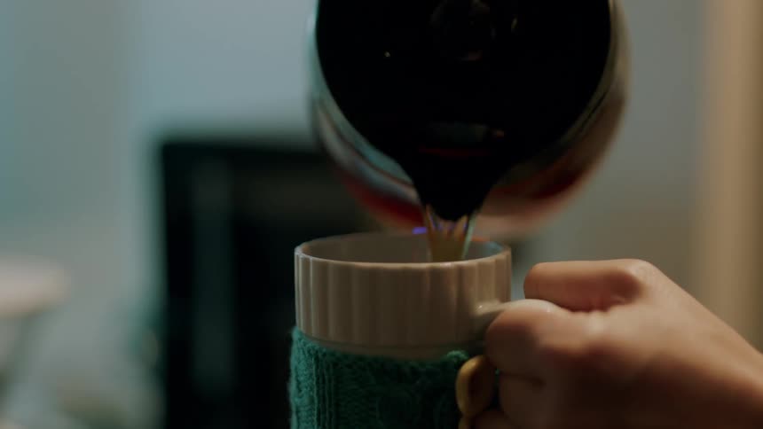 A person pouring coffee into a cup