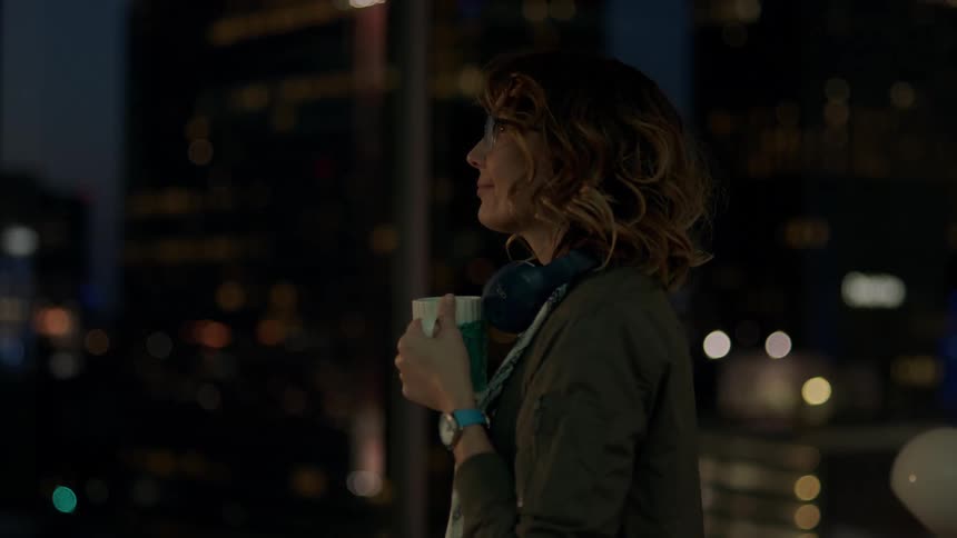 Businesswoman stands and sips her coffee in the office
