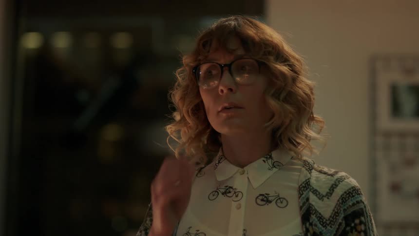 A woman looks around and then starts to reach for something