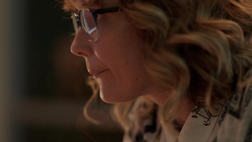 A woman leans forward tapping her head