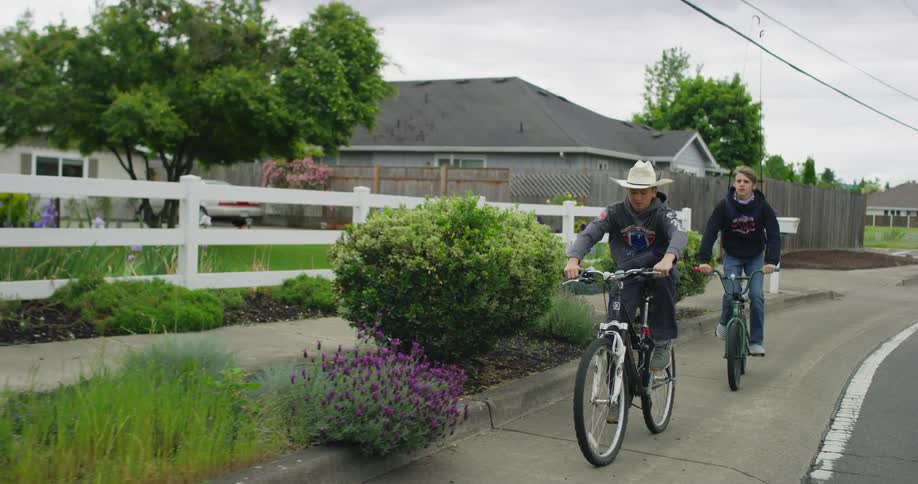 Boys riding bicycles down neighborhood street