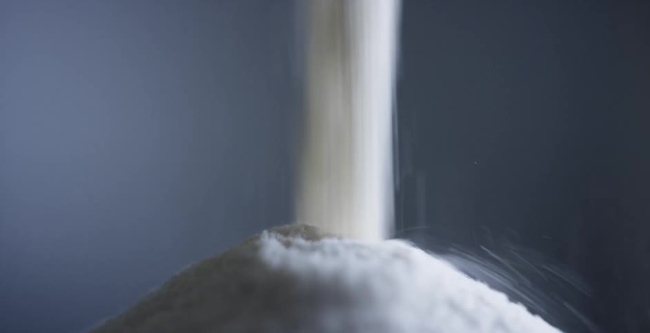 A white powder is poured into a mound against a gray background