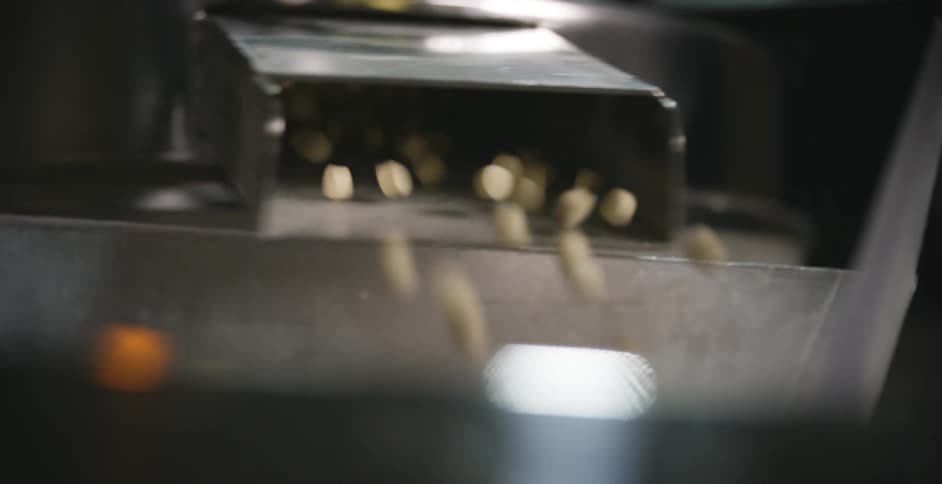 Pills being dispensed from a metal chute