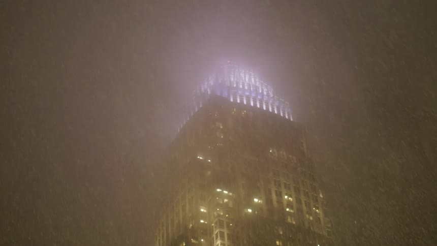 The snow falls on the building