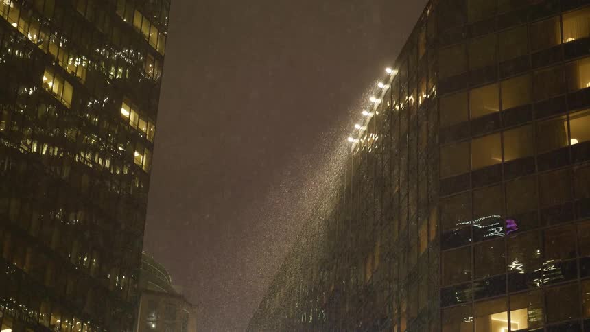 Snow falling in a downtown area