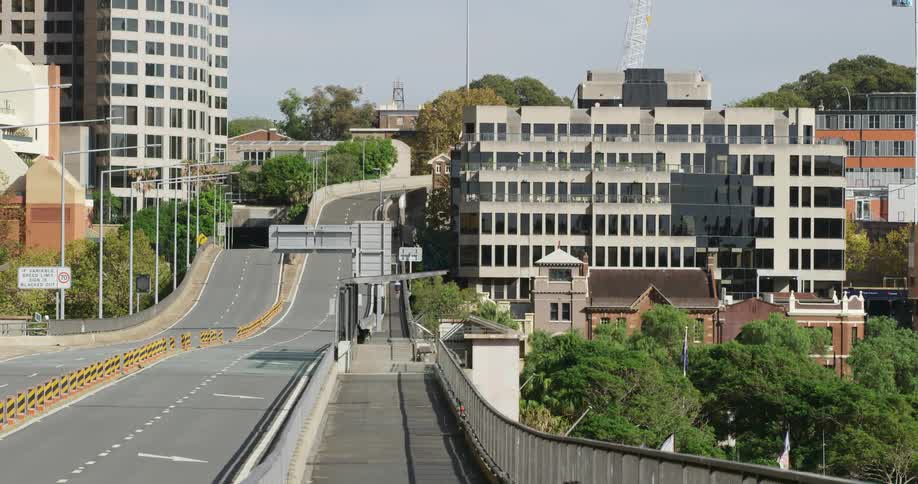 An overpass with buildings trees and the sky in the background