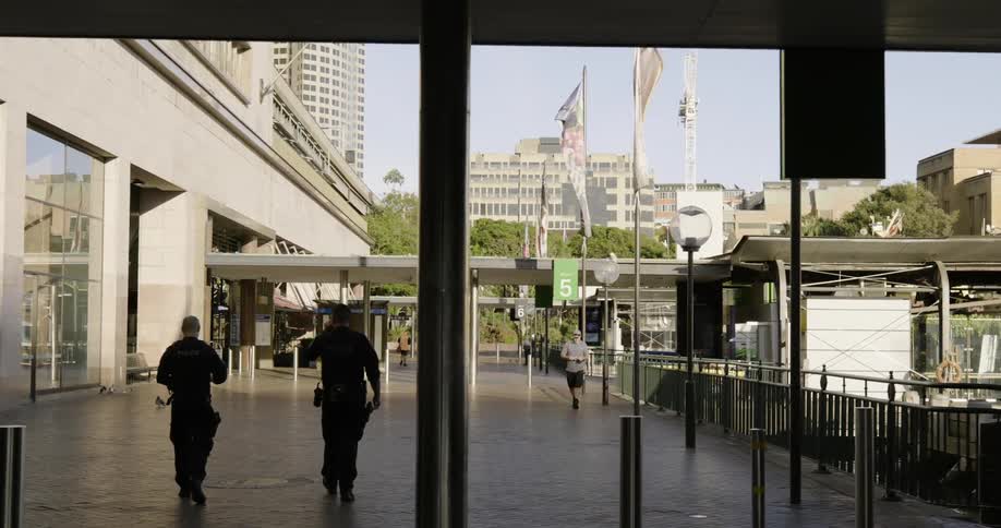 Two police officers walk around a station in downtown area