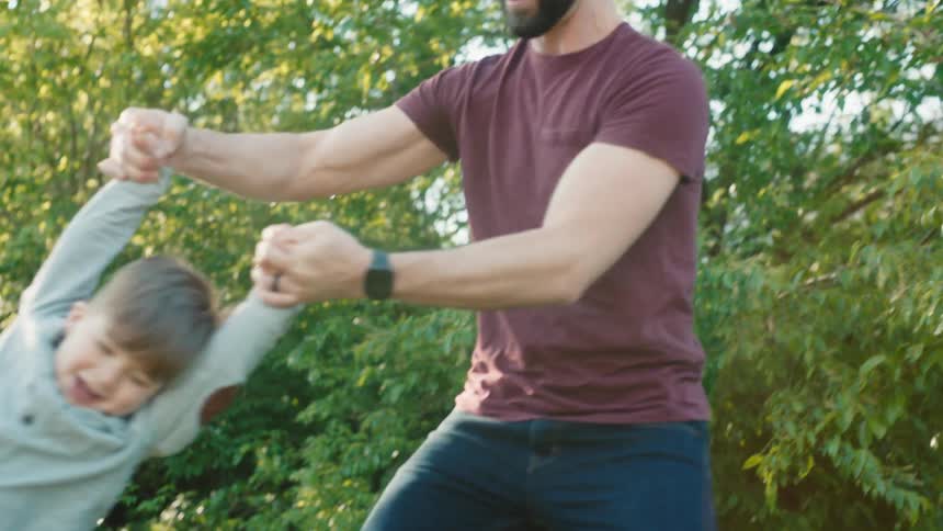 Father spins his son in the garden