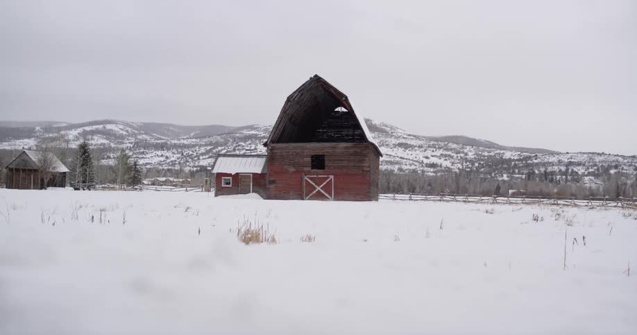 A barn sits on a snow covered field