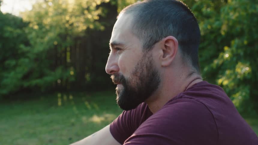 A man sits outside and smiles