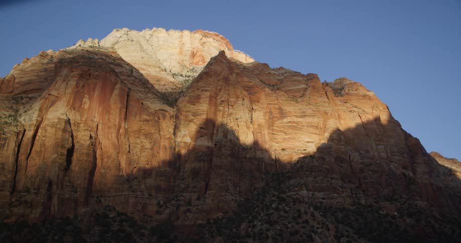 Mountain casts shadow on second mountain under a clear blue sky