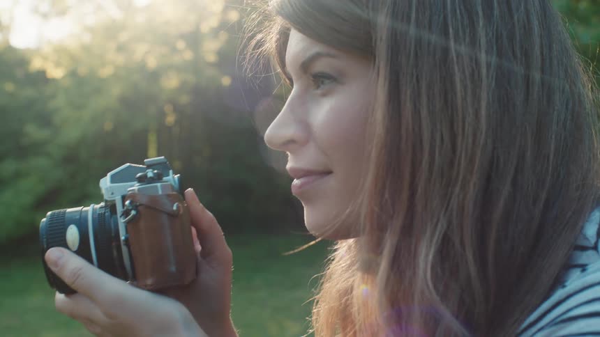 Woman takes a photograph of somebody in the garden