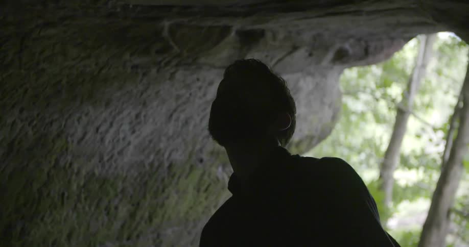 A man inside a cave looks around