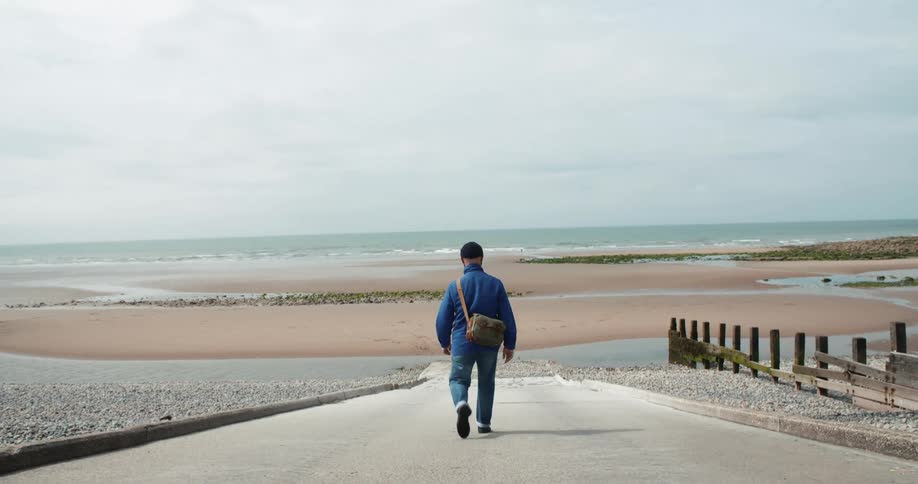 Photographer walks towards the beach