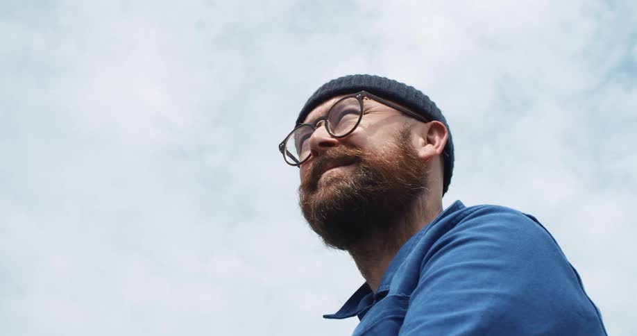 Bearded man wearing a beanie looks around