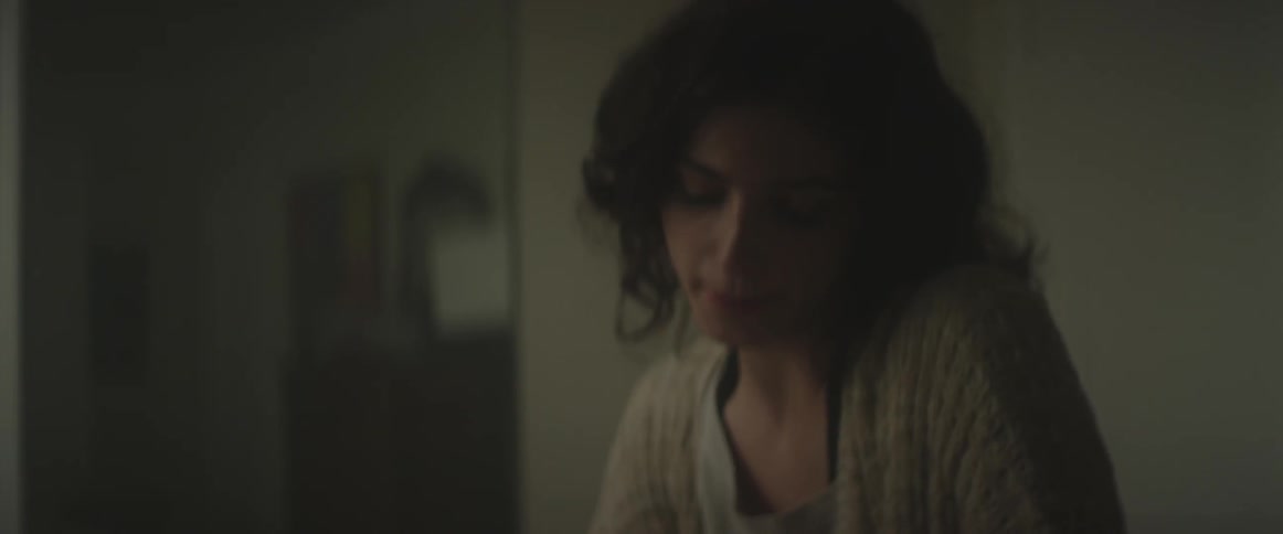 A woman talks and smiles inside a house