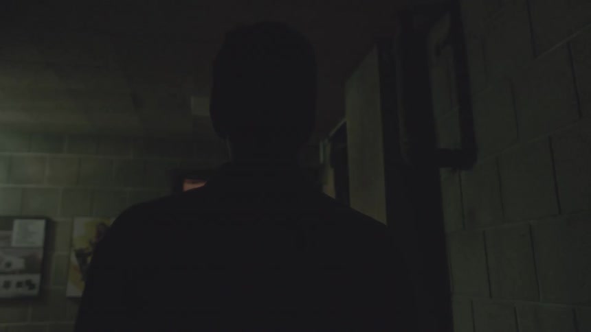 A light pulses and flashes in front of a man indoors