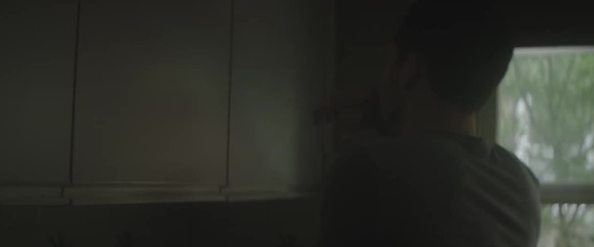 Man standing in a dark kitchen