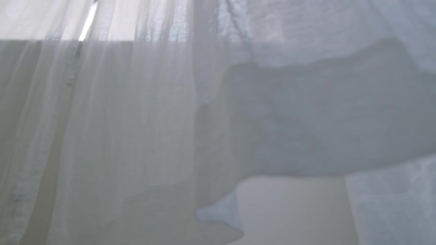 Wind blows the white window curtains