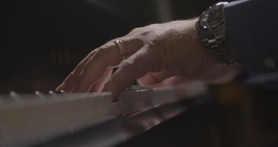 Close up of a person's hands playing a piano