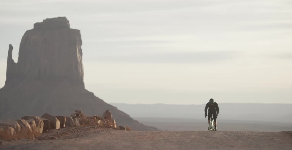 A man cycles past a large canyon