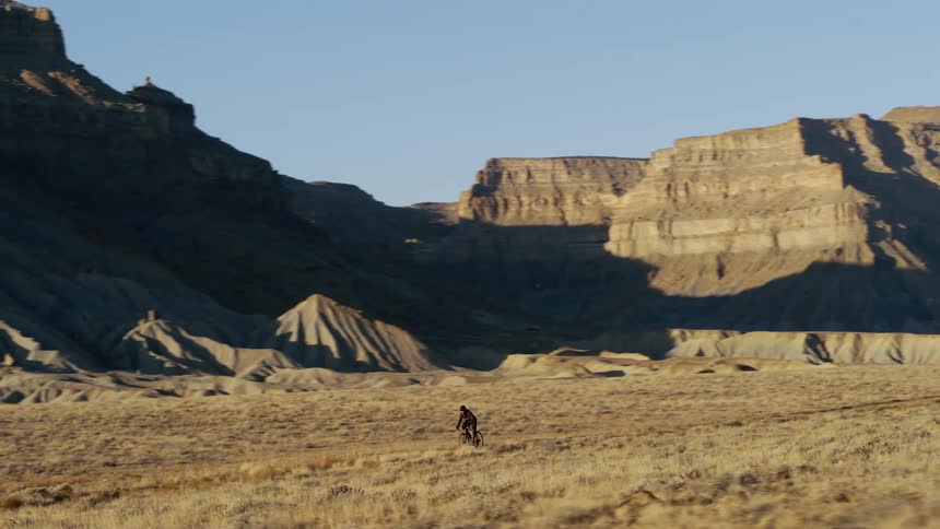 A man cycles through canyons