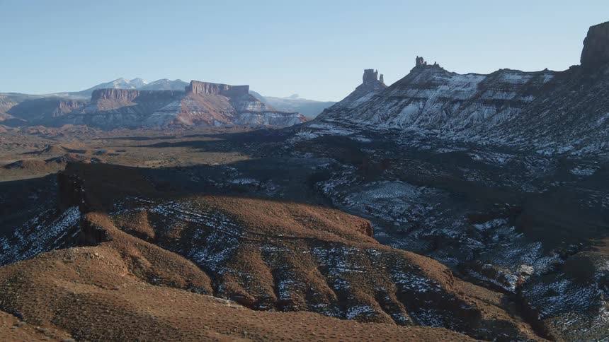 Snow covers parts of a mountain range and valley