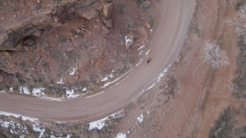 A person riding a bike on a curvy dirt road