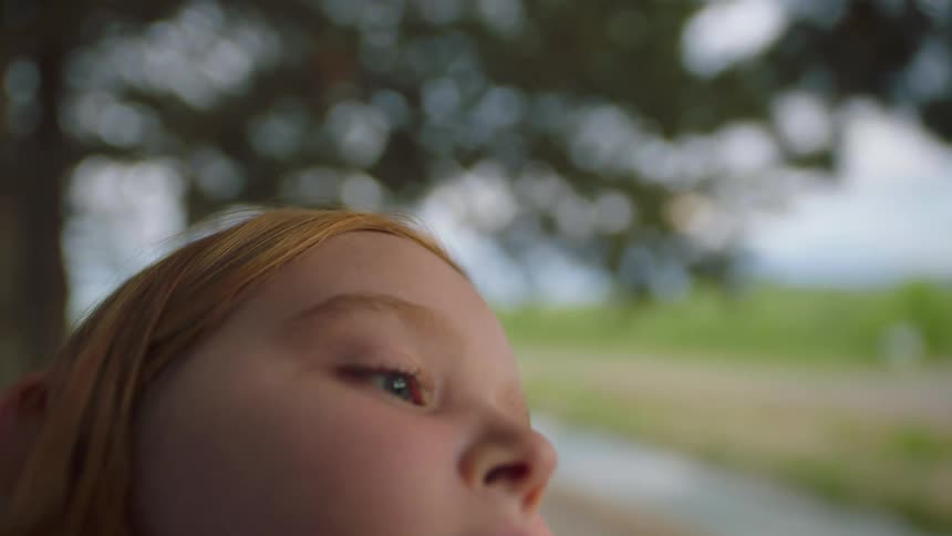 A young girl stares into the distance as she closes her eyes