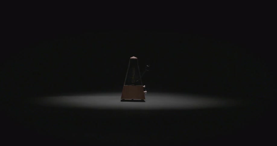 A metronome ticks in a dark room