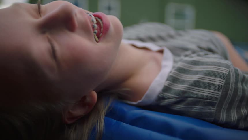 Two young girls lie on a trampoline and laugh