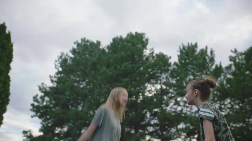 Two girls jump on a trampoline
