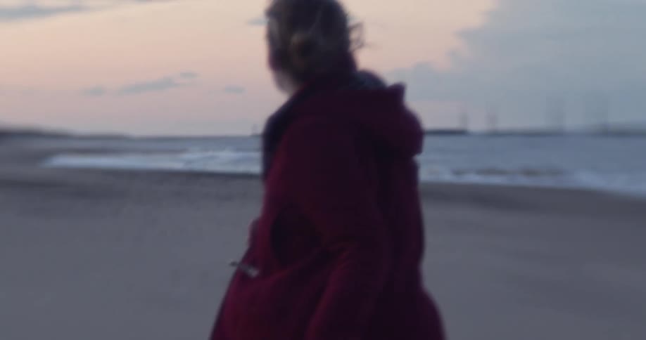 Woman runs on the beach at dusk
