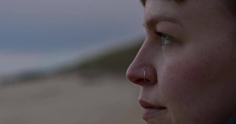 Close up profile of a woman standing looking out to the coast