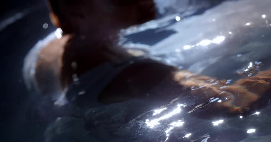 A woman sits and relaxes in a hot tub