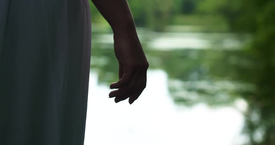 The woman stands by a lake