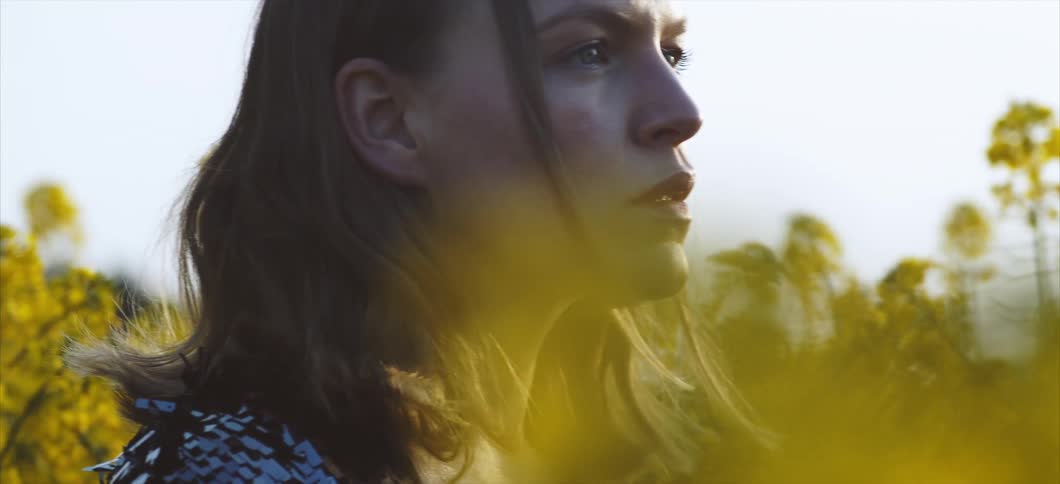 Woman sitting in a field of flowers at sunrise